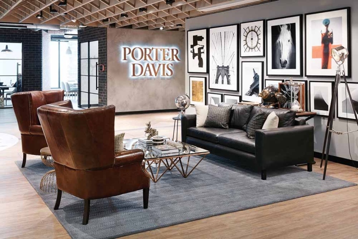 Стильный интерьер офиса - кожаные коричневые кресла и черный диван в зоне отдыха