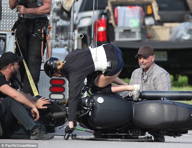 Safety first: Crew members talked her through every move in detail as the bike slowly tipped over