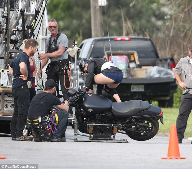 Climbing aboard: Margot was strapped into her harness before performing a stunt on the motorbike