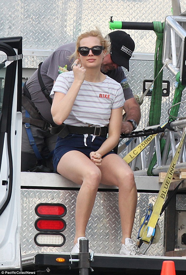 Sporty look: Margot teamed a stripy crop top with high-waisted denim shorts and trainers 