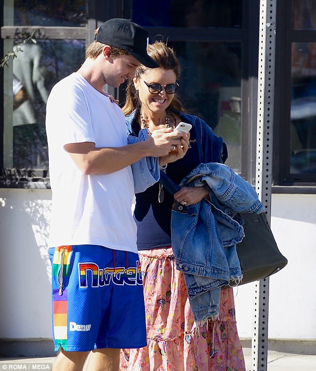 Sharing a smile: Patrick could be seen strolling beside his mother Maria Shriver