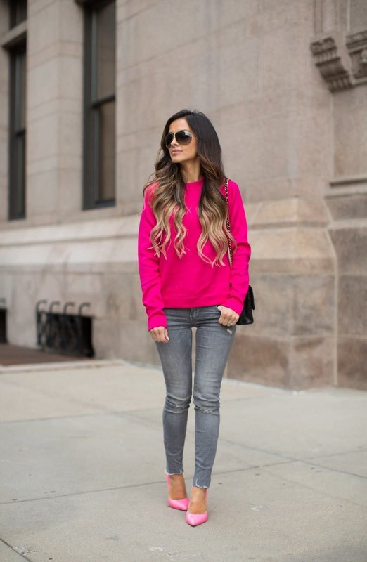 Девушка в ярком розовом свитере и джинсах-скинни