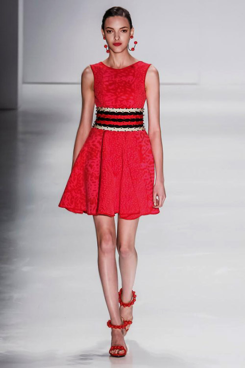 Модель в красном, коротком платье и красных босоножках на шпильке