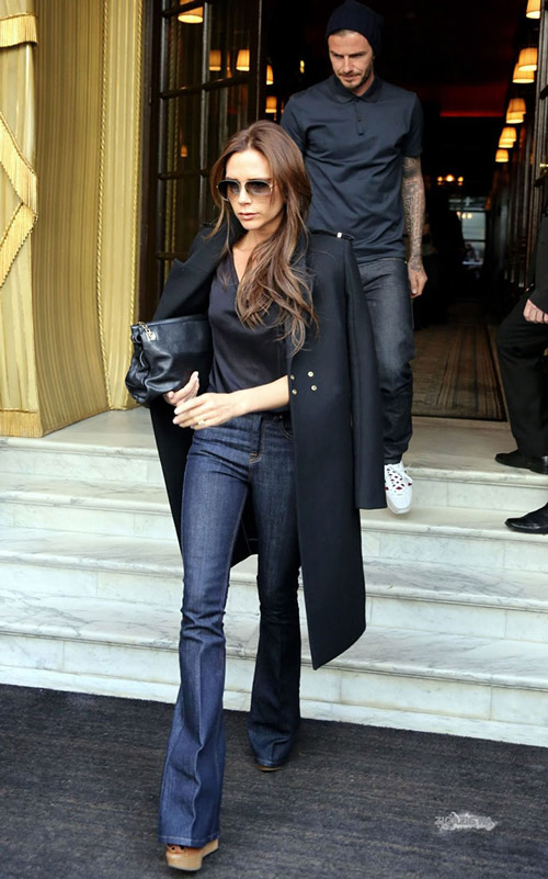 Виктория Бэкхем в черном пальто и джинсах клеш 