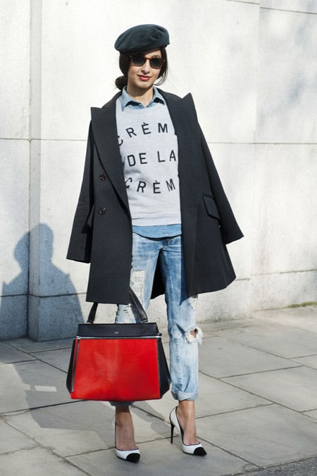 Модель в рваных джинсах, рубашка, черное пальто и кепка